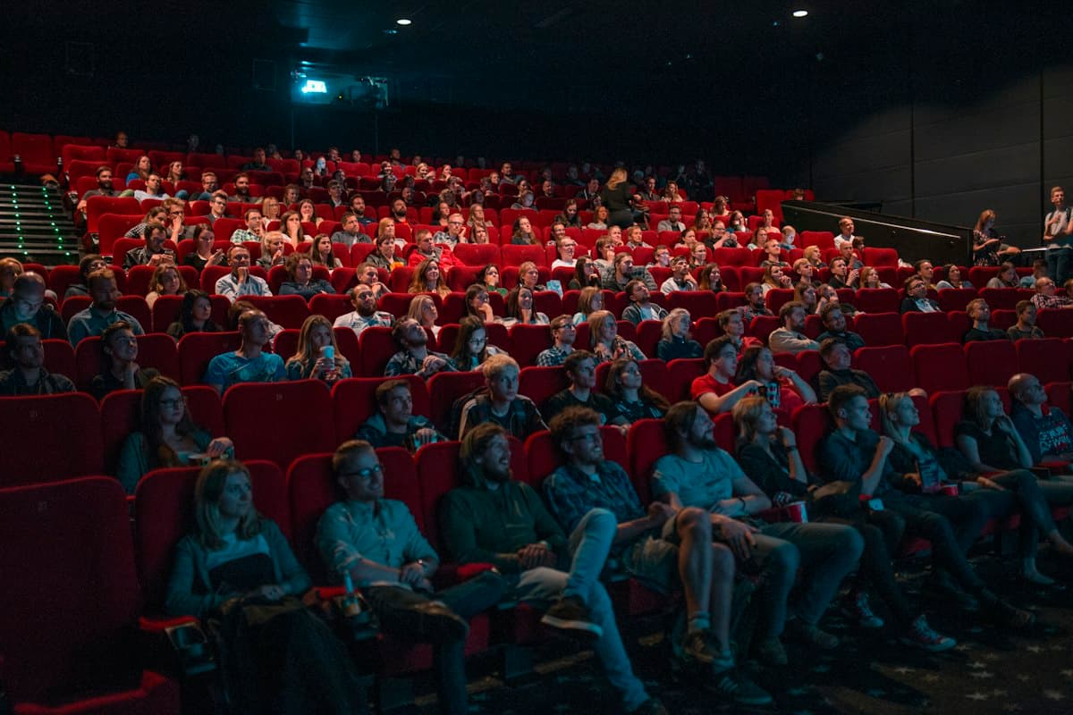 Audience seated in rows of red theater chairs